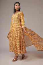 Model gracefully posing in the printed mustard yellow Anarkali dupatta set, showcasing the fluidity and elegance of the Anarkali and the dupatta's movement.
