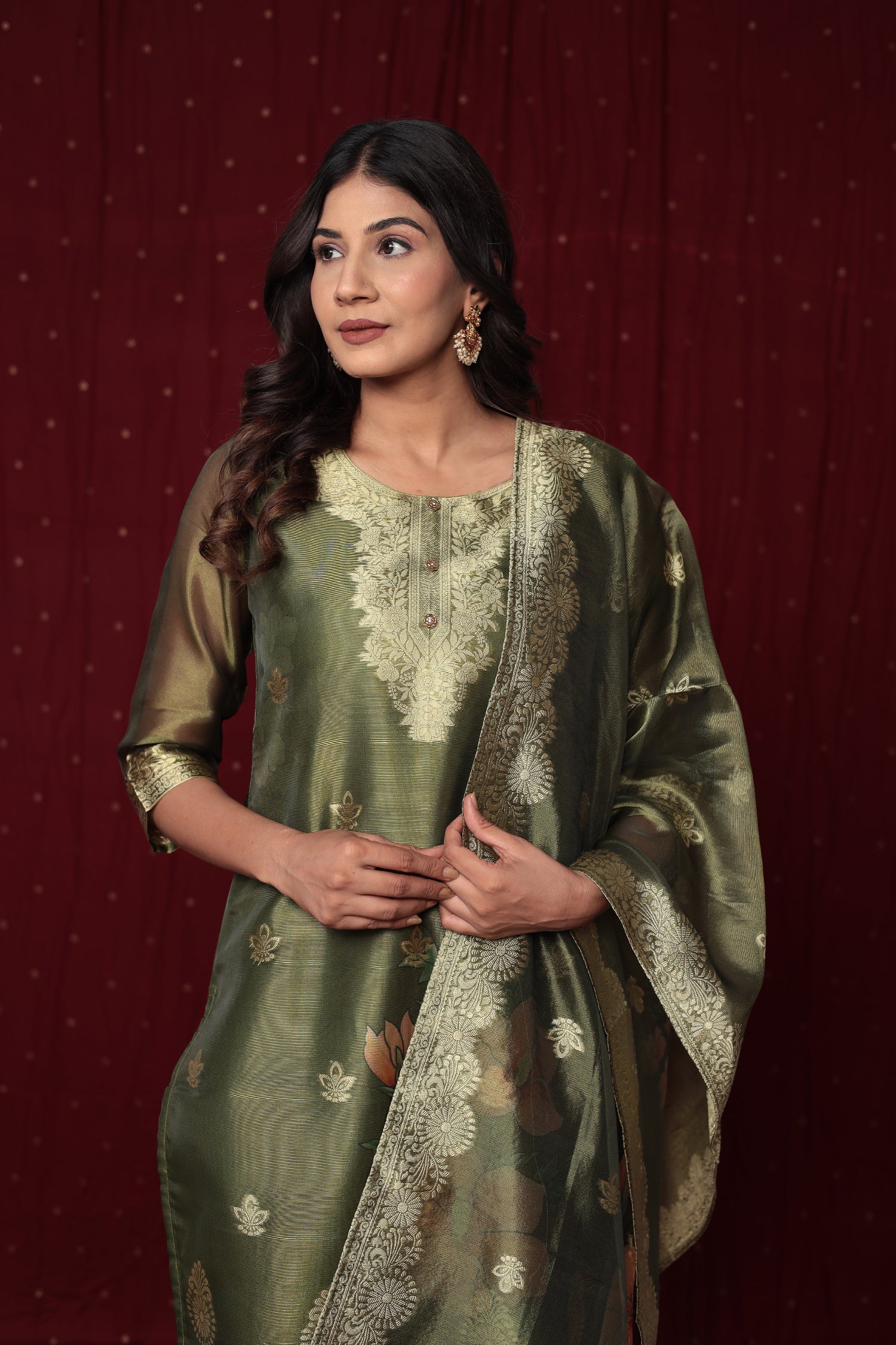 Close-up of the elegant gold embroidery on the neckline and the subtle woven jacquard patterns on the olive green organza kurti.