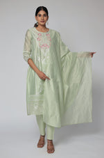 Model wearing an elegant pestal green Chanderi dupatta set from The Navra, featuring subtle all-over embroidery work on the kurti and matching dupatta, paired with comfortable pants. Ideal for sophisticated festive or semi-formal occasions.