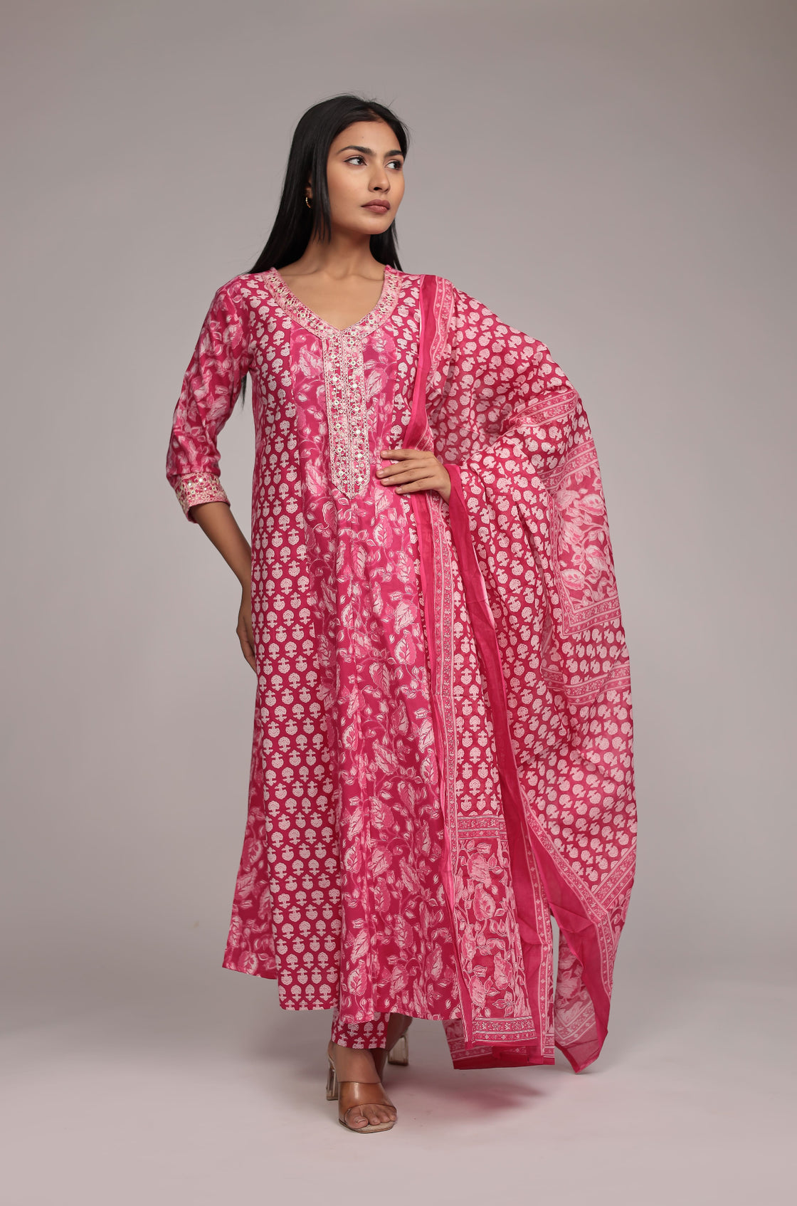Side profile of model showcasing the voluminous flare and elegant drape of the printed pink Anarkali dupatta set.