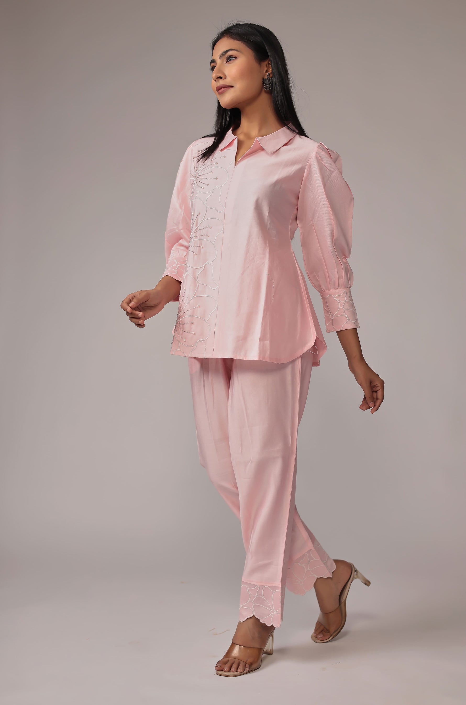 Model in a confident stance, highlighting the full length and overall stylish design of the pink co-ord set with creative work.

