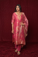 Side profile of model showcasing the graceful flow and rich look of the deluxe pink jacquard organza suit and dupatta.