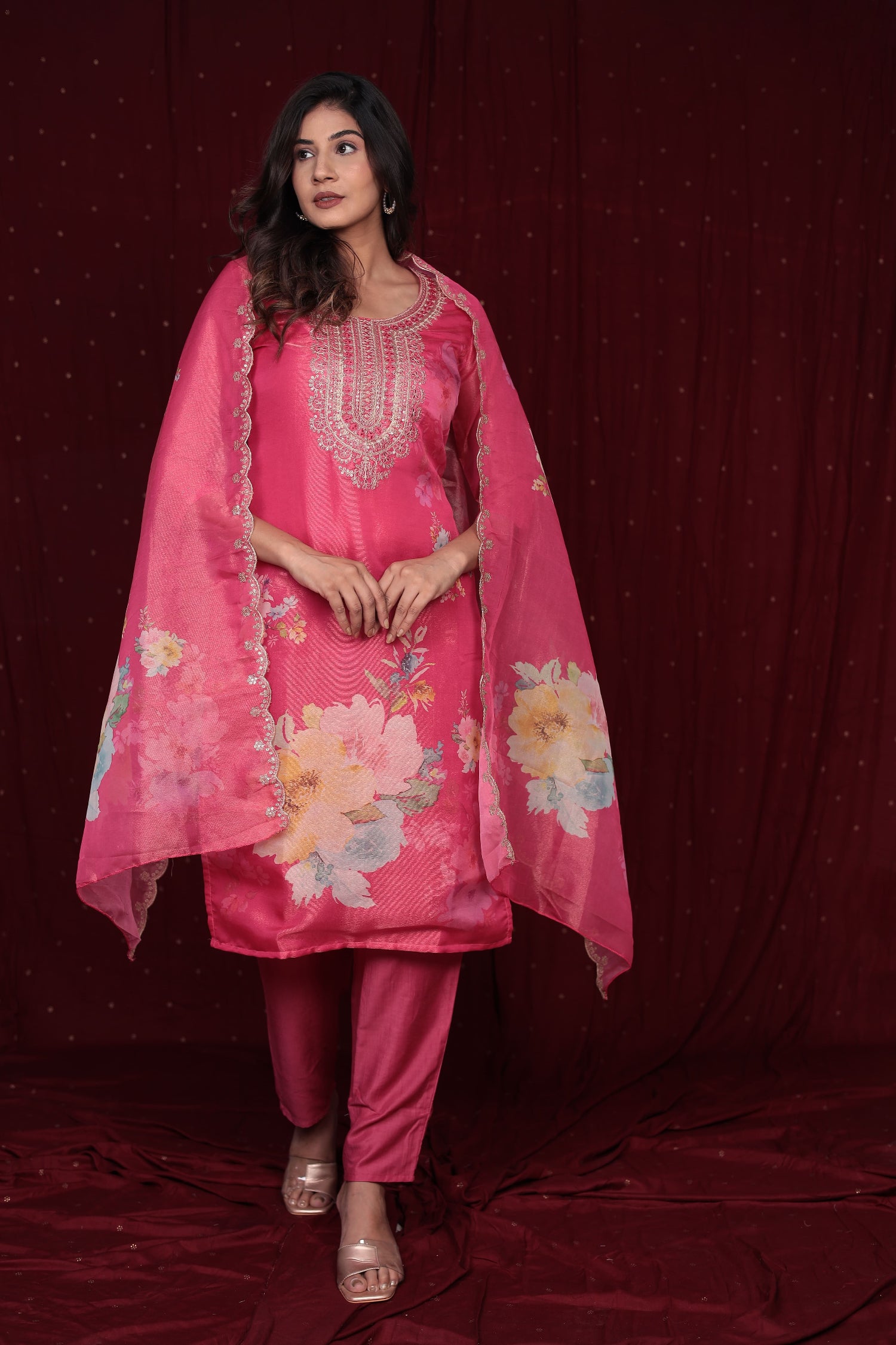 Side profile of model showcasing the flow and fit of the deluxe pink ethnic suit and organza dupatta.