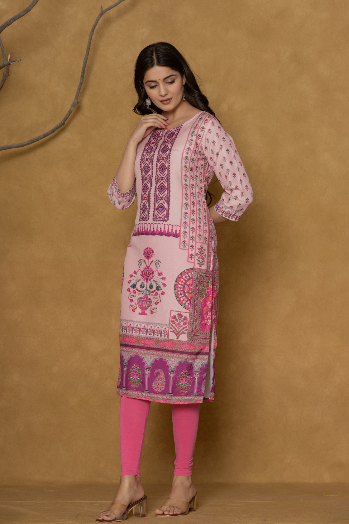 Model wearing a vibrant pink kurta from The Navra, intricately detailed with handwork on the round neck and featuring multi-layered block prints, paired with bright pink leggings. Ideal for comfortable daily or casual ethnic wear.