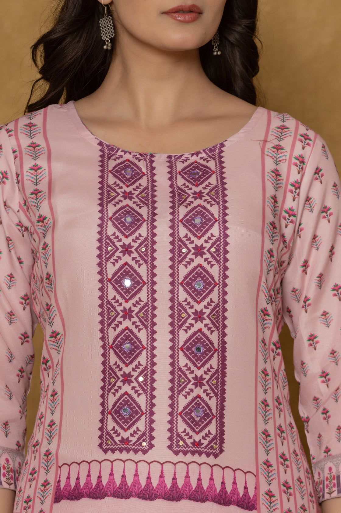 Close-up of the beautiful multi-color handwork embroidery and intricate patterns on the round neckline of the pink kurta, highlighting fine craftsmanship.