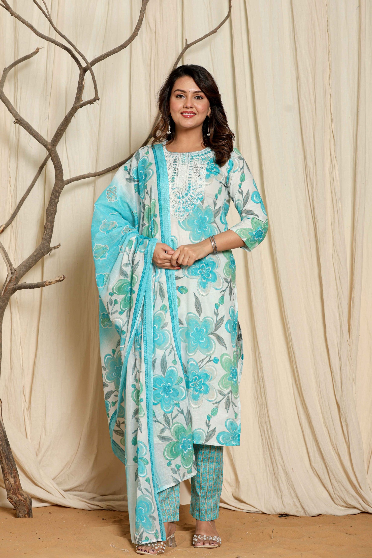Model wearing a premium cotton floral printed dupatta kurta set from The Navra, featuring vibrant turquoise and green floral prints on the white kurta, with a matching patterned dupatta and pants. Ideal for comfortable daily or casual ethnic wear.