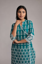 Close-up of the exquisite white sleek embroidery and intricate patterns on the V-neckline and front of the Rama green kurta.