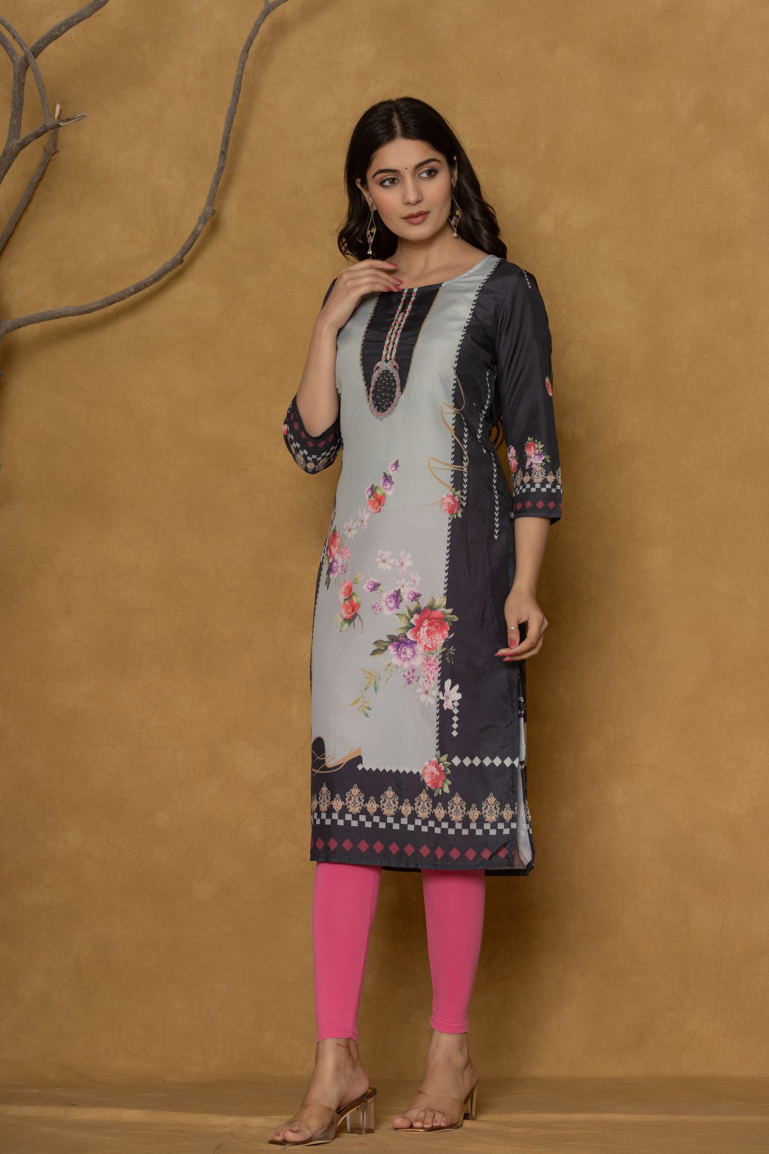 Model wearing a rich black pannel kurta from The Navra, featuring intricate handwork on the neck and elegant floral prints, paired with bright pink leggings. Ideal for stylish daily or casual wear.