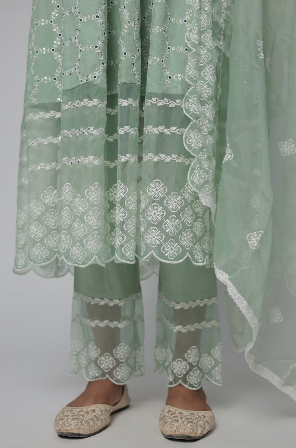 Detailed view of the sage green Chikankari Anarkali kurta and cotton pant, highlighting the all-over white embroidery and fabric texture.