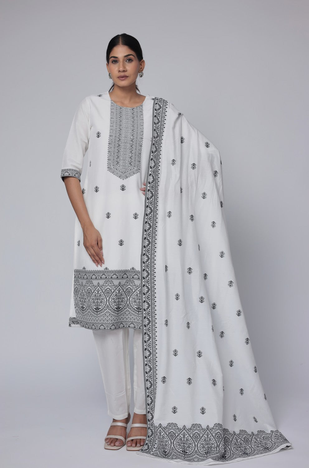 Model wearing an elegant off-white and black cotton jacquard dupatta set from The Navra, featuring intricate black geometric detailing and embroidery on the front of the kurta and a matching patterned dupatta. Ideal for sophisticated daily or semi-formal ethnic wear.