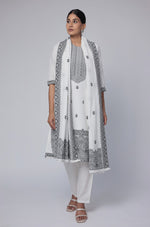 Model in a confident stance, highlighting the full length and overall elegant design of the off-white and black cotton jacquard dupatta set, with dupatta draped over shoulder.