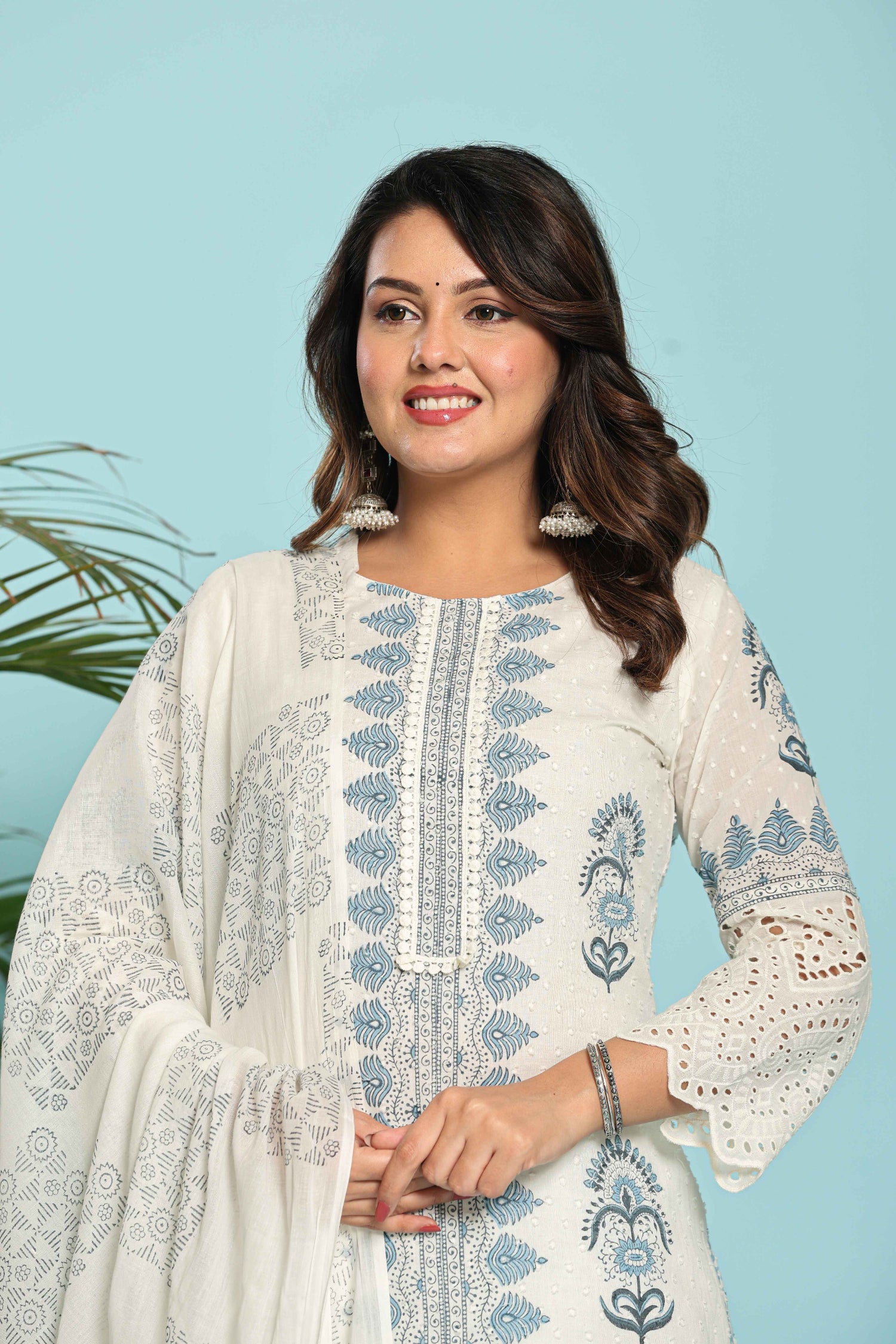 Close-up of the delicate white embroidery on the V-neckline and intricate blue hand block print on the white kurta, highlighting fine craftsmanship.
