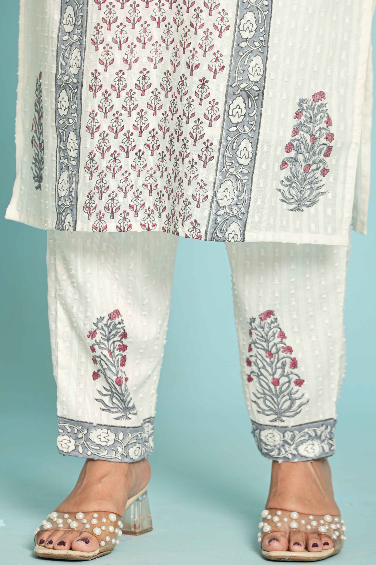 Close-up of the white pant with intricate grey hand block print and model's sandals, highlighting the comfortable fit and styling.