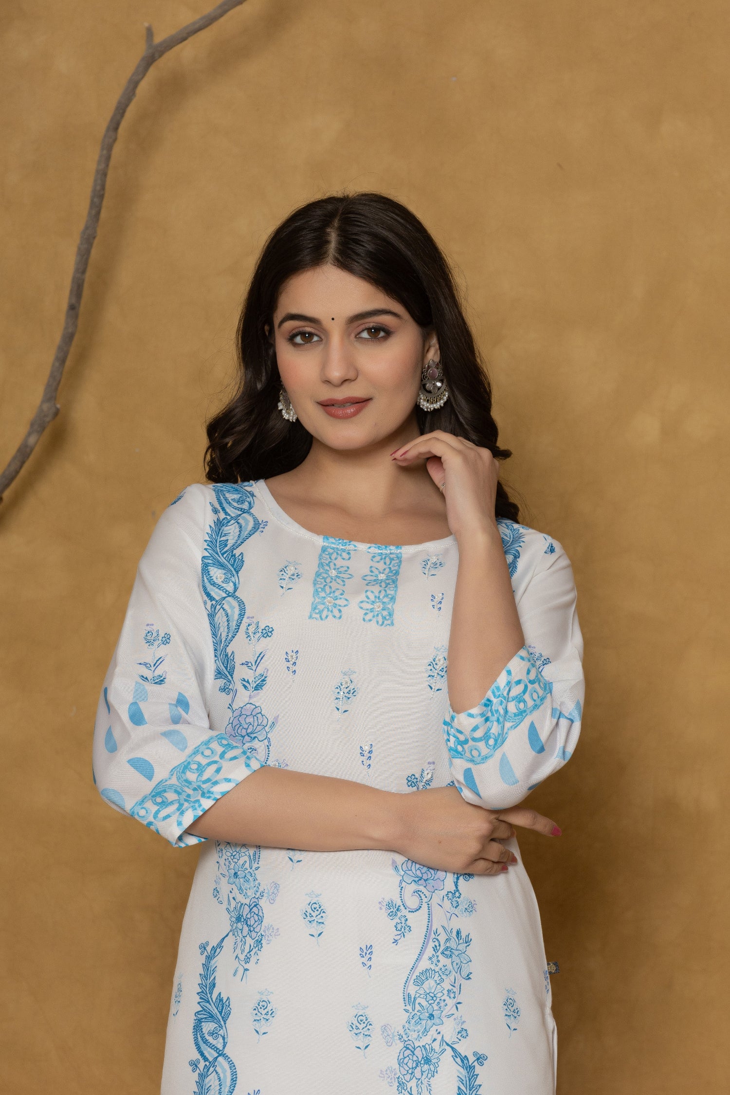 Close-up of the delicate blue handwork embroidery and detailing on the round neckline of the white kurta, highlighting fine craftsmanship.