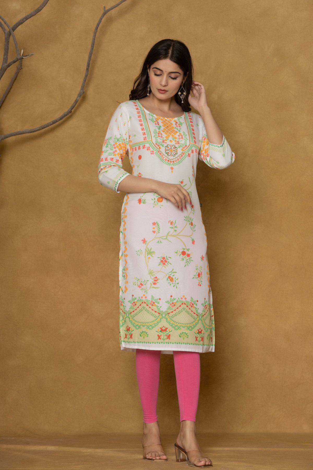 Model in a different pose wearing the white and lime pannel kurta, highlighting the full length and the cheerful floral patterns at the bottom.