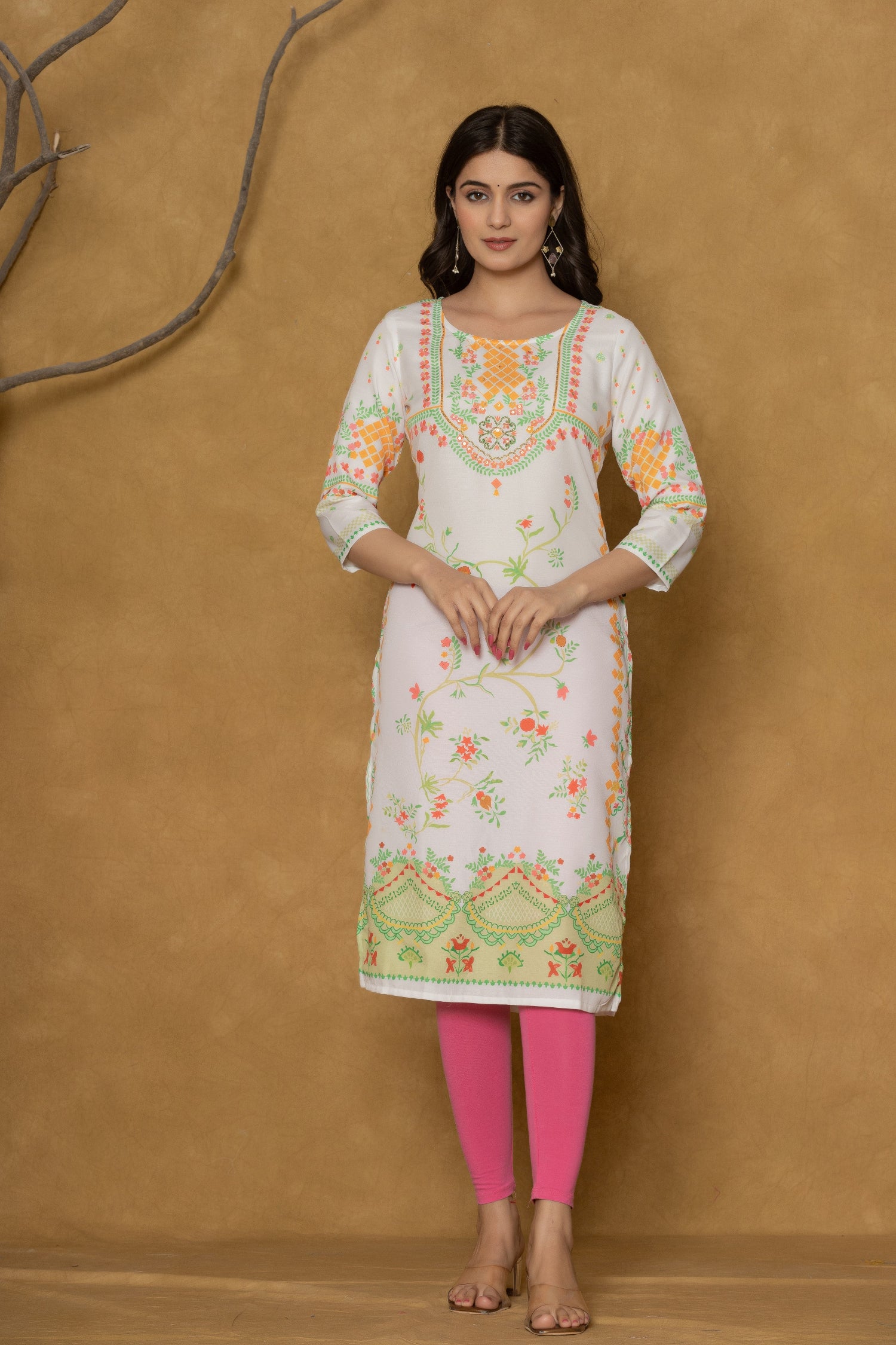 Close-up of the delicate floral and geometric pattern in lime green and orange along the hemline of the white pannel kurta, showcasing the fabric and design detail.