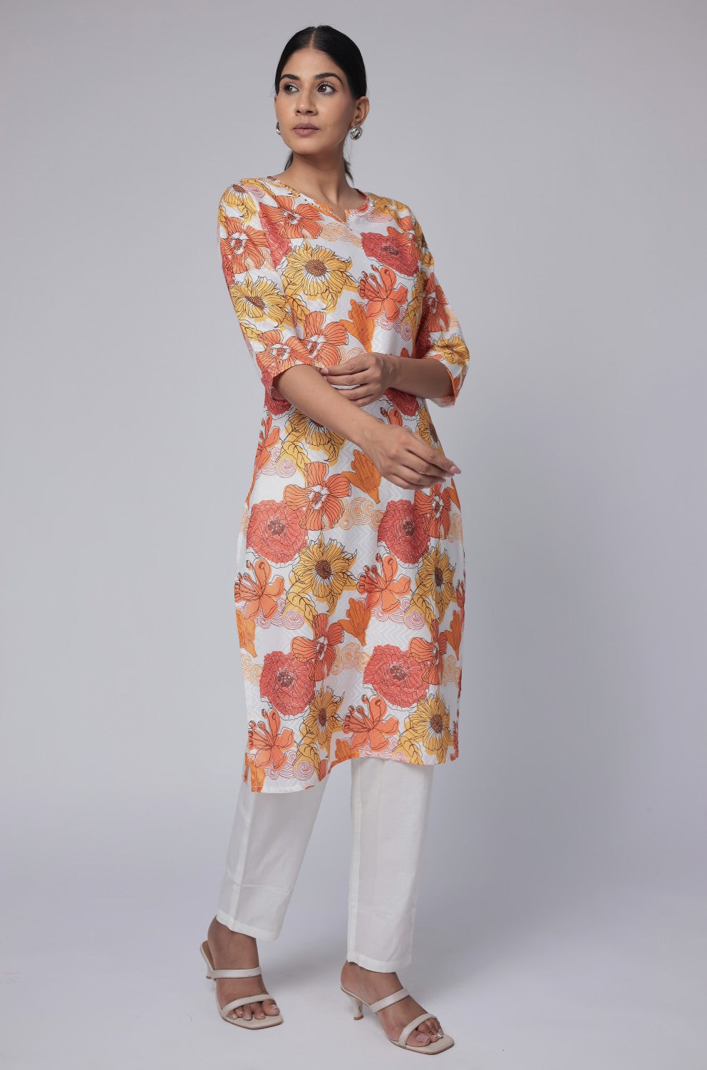 Model in a confident stance, highlighting the full length and overall vibrant floral print design of the white multicolor cotton dobby kurti.