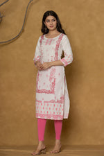 Model wearing a white pannel kurta from The Navra, featuring intricate handwork on the round neck and delicate pink floral patterns along the hemline, paired with bright pink leggings. Ideal for casual and daily ethnic wear.