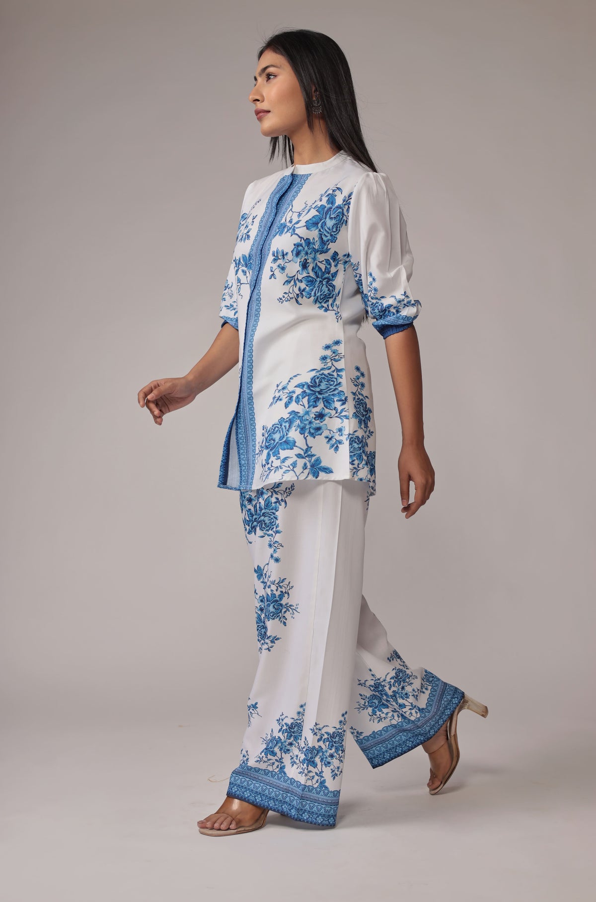 Side profile of model in a walking pose, showcasing the comfortable movement and graceful drape of the white and royal blue digital print co-ord set.