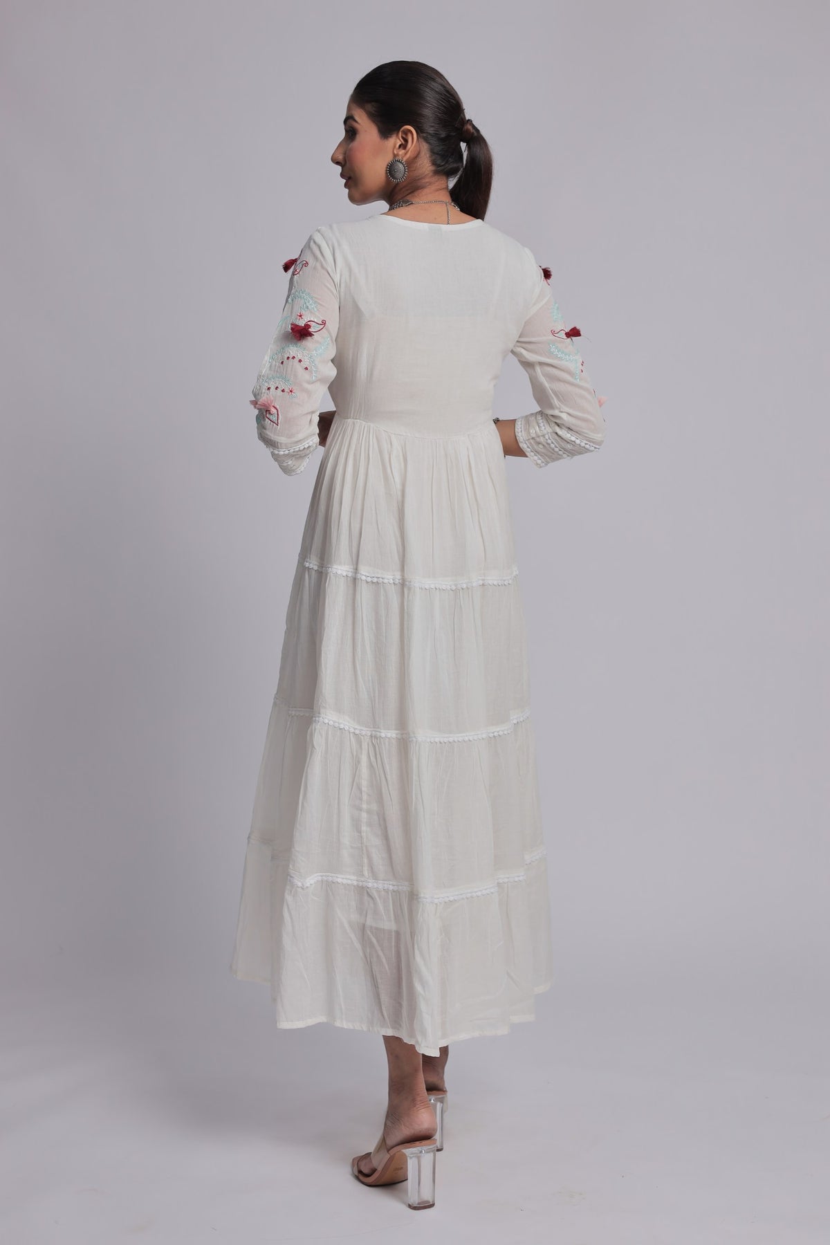 Back view of the white tiered Anarkali dress, showing the consistent fabric pattern and comfortable silhouette.