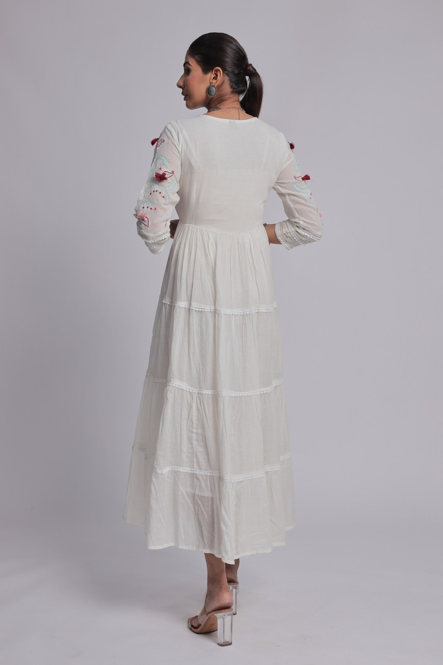 Back view of the white tiered Anarkali dress, showing the consistent fabric pattern and comfortable silhouette.