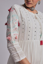 Detailed view of the sleeve and textured fabric of the white tiered Anarkali dress, showing subtle embroidery and embellishments.