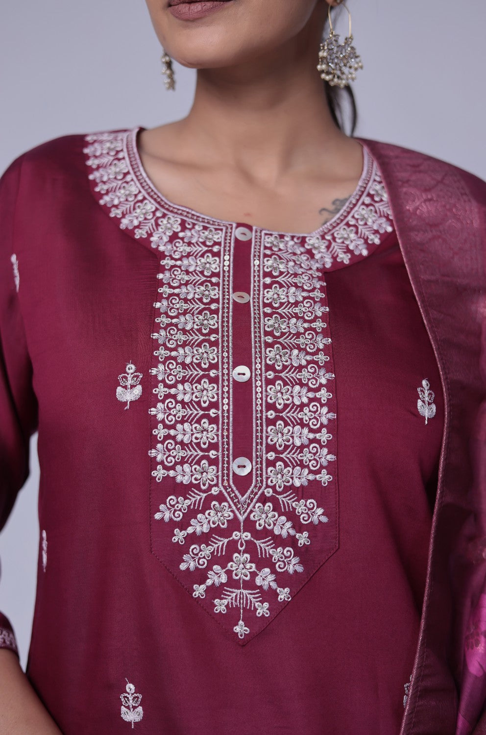 Close-up of the intricate white thread embroidery and shimmering sequins on the neckline and front of the wine soft silk kurta, highlighting fine detailing.
