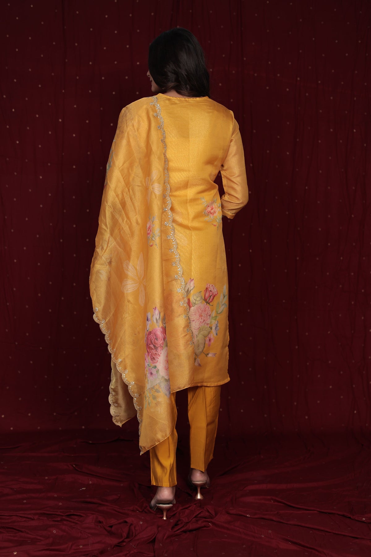 Side profile of model showcasing the flow and fit of the deluxe yellow ethnic suit and organza dupatta.
