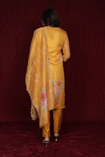 Side profile of model showcasing the flow and fit of the deluxe yellow ethnic suit and organza dupatta.