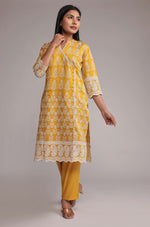 Model wearing a bright yellow kurta pant set from The Navra, featuring intricate white allover embroidery on the kurta and comfortable matching pants. Ideal for stylish daily or festive occasions.