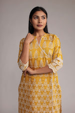 Model gracefully posing in the yellow kurta pant set, showcasing the comfortable movement and elegance of the allover embroidered kurta.