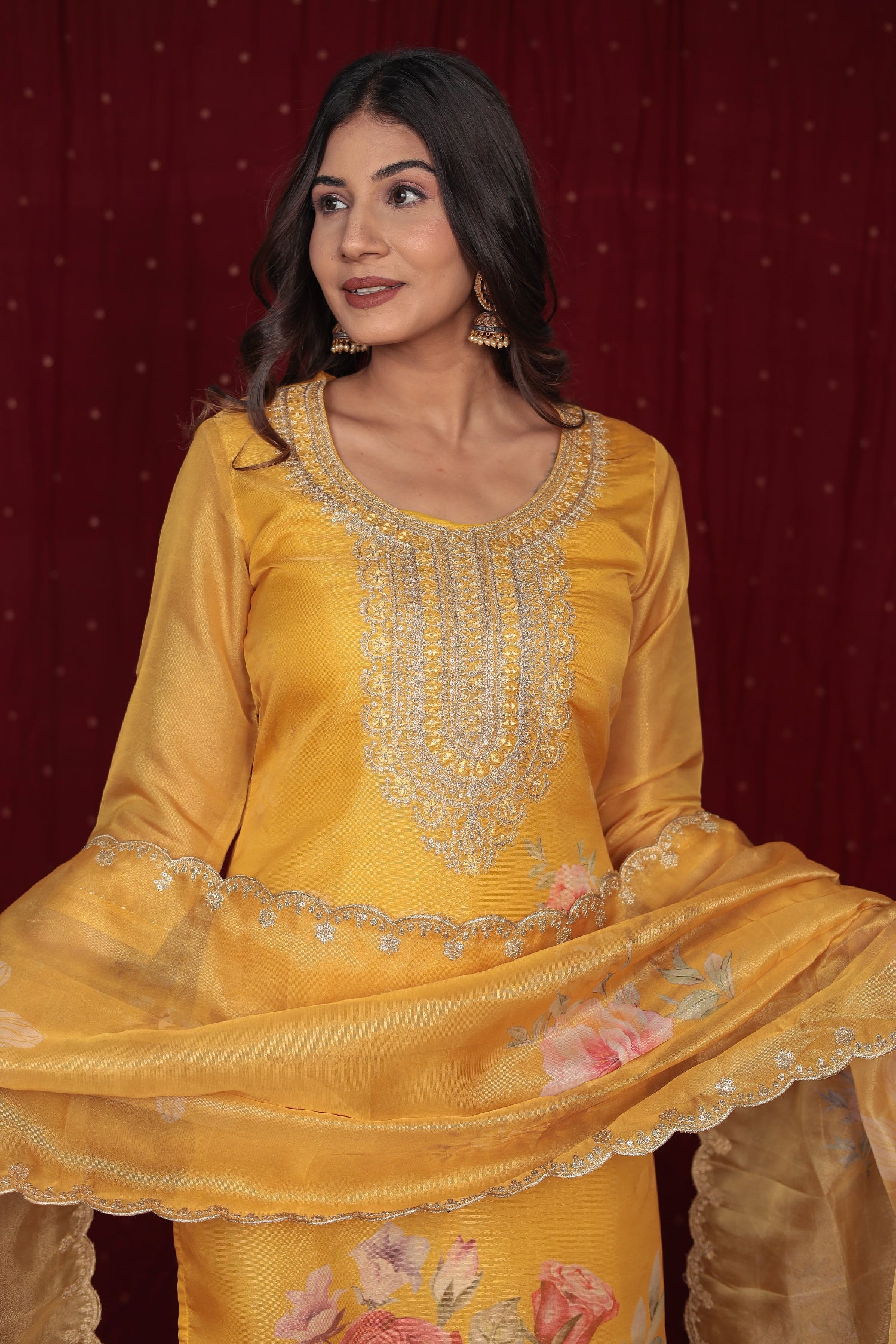 Close-up of intricate gold and white embroidery on the neckline and front of the deluxe shimmer organza yellow kurti.